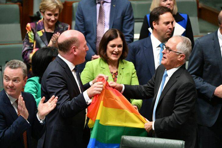 Liberal Member for North Sydney Trent Zimmerman and Prime Minister Malcolm Turnbull celebrate the passing of the Marriage Amendment Bill in the House of Representatives at Parliament House in Canberra, Thursday, December 7, 2017. (AAP Image/Mick Tsikas) NO ARCHIVING