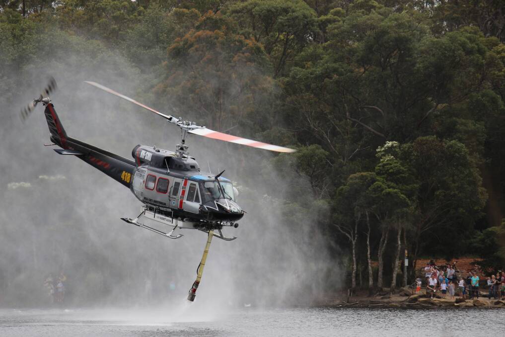 A water bombing helicopter fills up its container at Glenbrook Lagoon. Photo: Michael Bourne