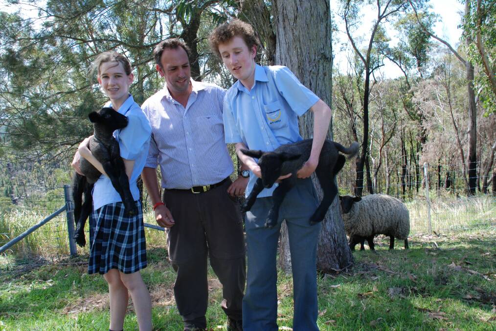 Agriculture teacher helps Year 10 students Tim Pout and Millie Hyssett with the newest additions to the school's sheep family.