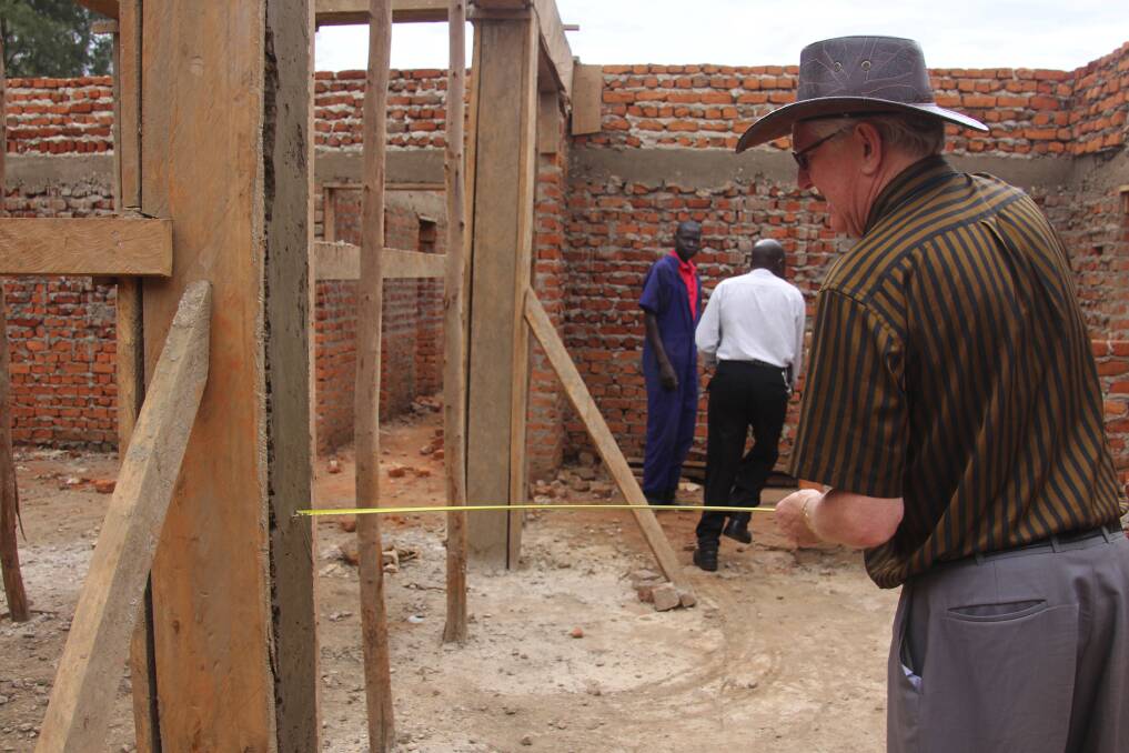 Graham Toulmin has been working tirelessly for 25 years to bring dental respite to the people of the troubled Congo. He is seen here measuring out space for cabinets in the student clinic.