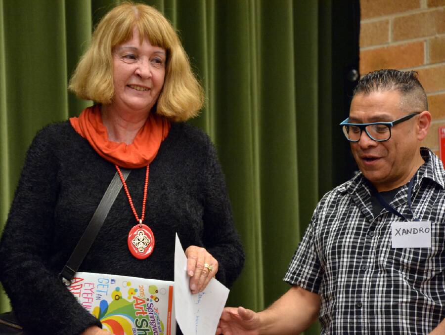 Janet Andersen receives the Springwood Art Show landscape prize from Parents and Citizens Association member Xandro Lombardi.