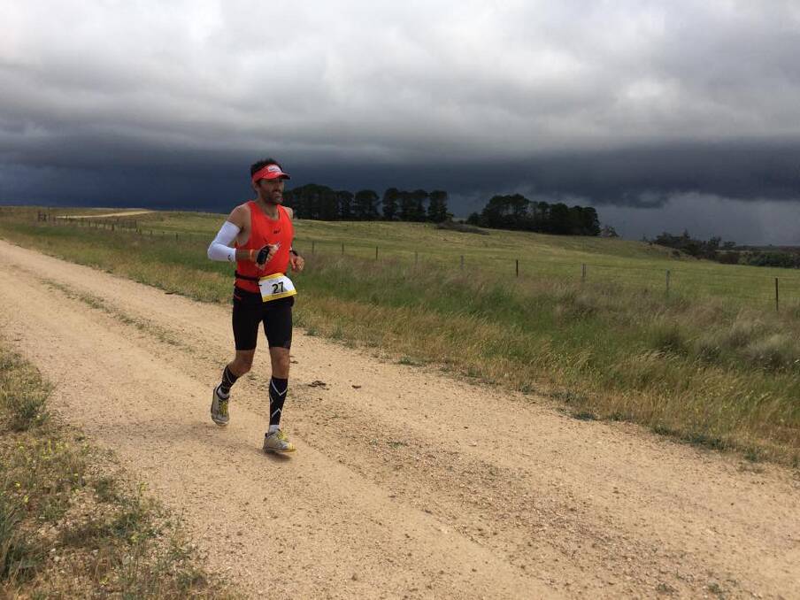 Woodford's Brendan Davies runnning towards the Australian Alps as storm clouds loom overhead during the 2014 Coast to Kosci 240km ultramarathon last weekend. Just two weeks earlier he was competing at the IAU 100km World Championships in Qatar.