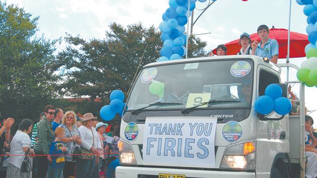 Crowds cheer on a float in the grand parade that pays tribute to the efforts of Blue Mountains firefighters.