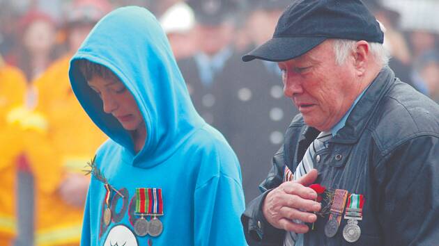 A man and his grandson pause to pay their respects after laying a wreath at the cenotaph at Lawson.