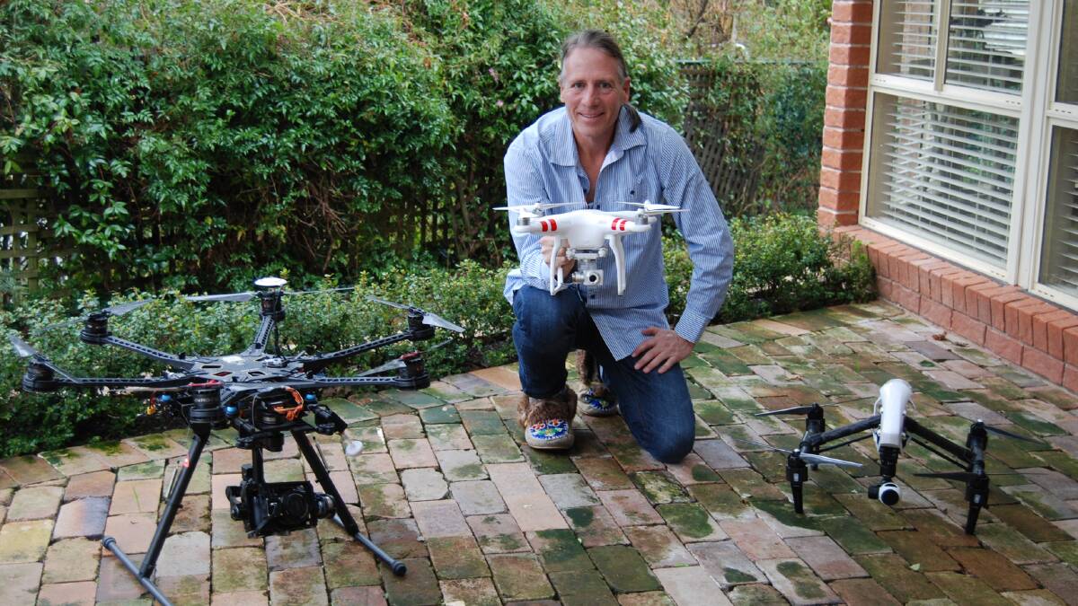 Scott Goodkin at home with his three drones.