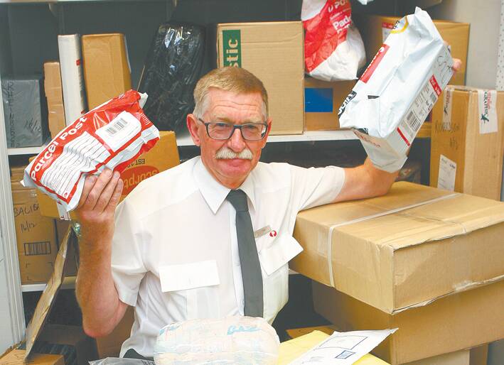 Tim Forde, postal manager at Springwood, inundated with parcels at Springwood's busy post office last week.
