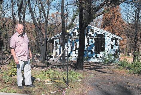 Councillor Don McGregor outside one of the burnt-out houses in Mt Victoria that is yet to be cleared.