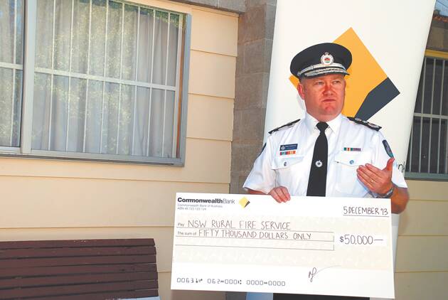 NSW RFS Commissioner Shane Fitzsimmons accepts the $50,000 donation from the Commonwealth Bank in Springwood last week.