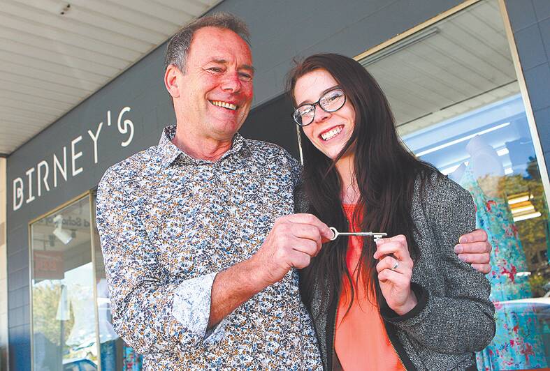 Ross Birney hands the shop key to new Birney's Springwood owner Sarah Warrick, 19, from Winmalee last month. The shop is hosting a special Christmas shopping night this Thursday from 6pm.