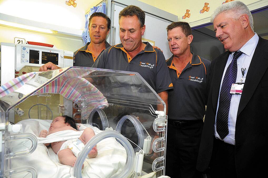 Making a difference: Six-week-old Olivia Thompson in her crib at Nepean Hospital with the Great Walk’s Greg Nelson, Jonathan Green, Rob Wearn and hospital general manager Kevin Hedge. Photo: Mike Sea.