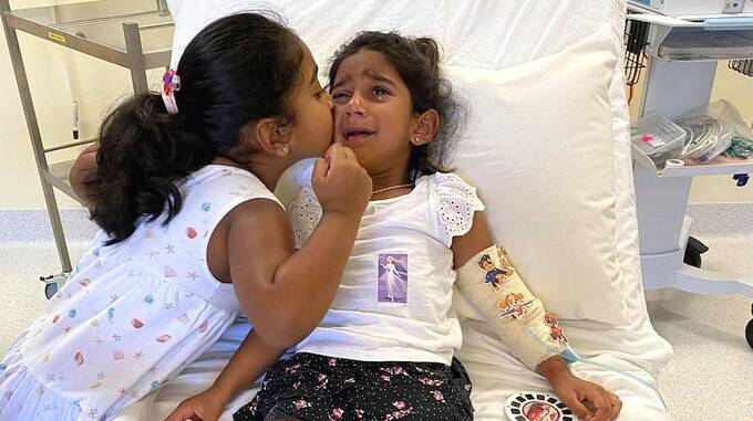 Kopika comforts her younger sister, Tharnicaa, who is now being treated in a Perth hospital. Picture: Supplied