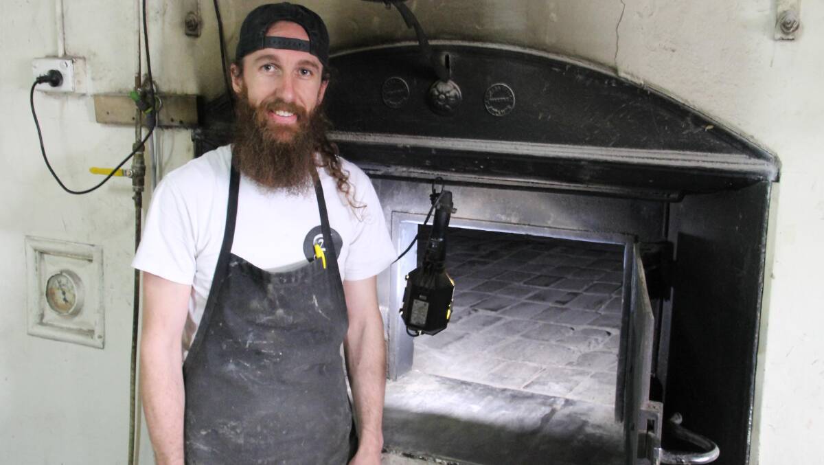 Corey Fechner … with the wood-fired oven whose flame has supposedly never been extinguished.