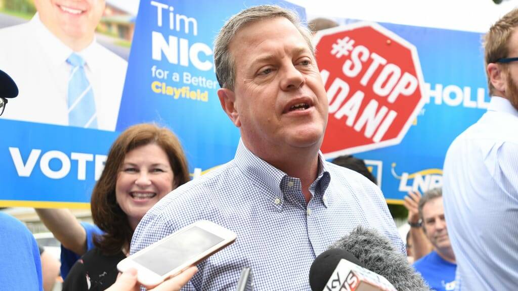 Opposition Leader Tim Nicholls is surrounded by anti-Adani protestors as he arrives to vote in his electorate of Clayfield on Saturday.
