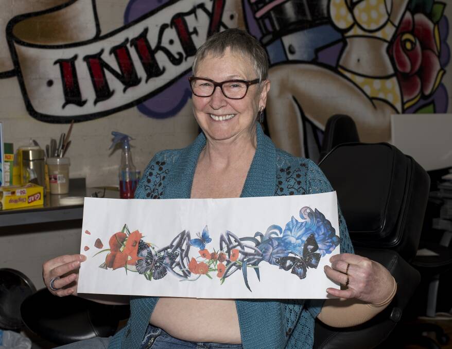 Full colour: Deb Wells with the design now tattooed across her chest. It includes butterflies (rebirth), gladioli (strength) and Flanders poppies for remembrance.