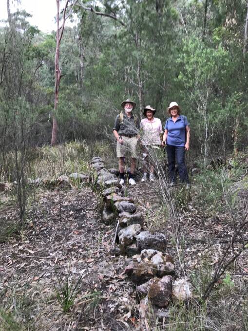Mystery solved: Martin Haley, Moya Haley and Jenny Foster at the stone cross in Sassafras Gully.
