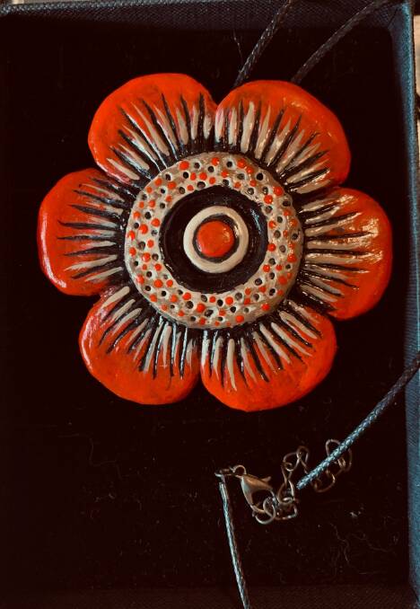 Orange and black hand-made ceramic pendant by Lisa Frances Judd.