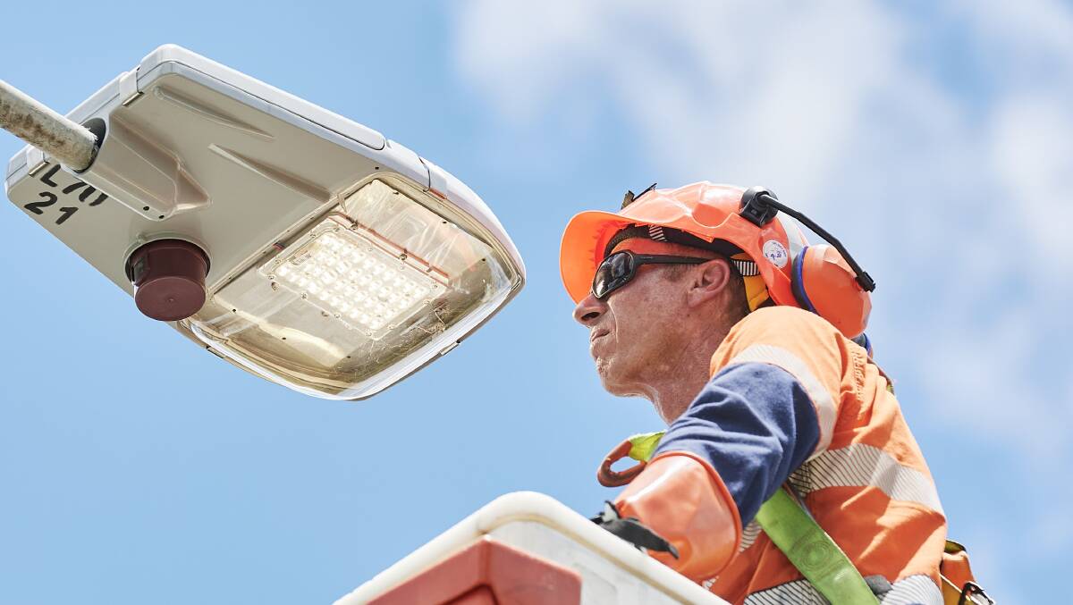 An Endeavour Energy technician installs a new LED street light. Pictured supplied 