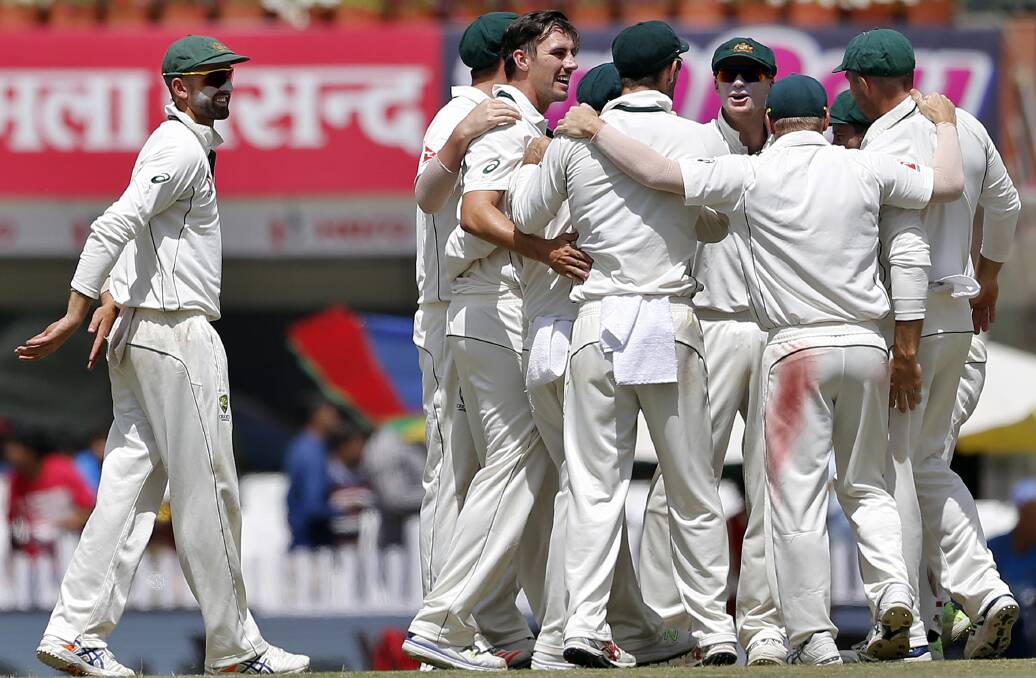 Comeback kid: Pat Cummins (without cap) is congratulated by his teammates after claiming the scalp of India's captain Virat Kohli on day three of the third Test in Ranchi. Photo: AP