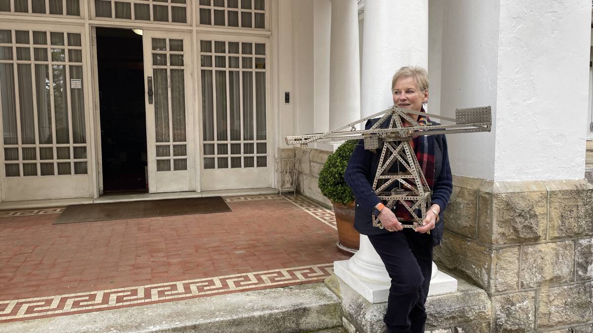 Elizabeth Evatt on the steps of Leuralla, holding a Meccano model of the hammerhead crane that used to dominate Garden Island in Sydney. It was made by her late husband, Clive Evatt junior.