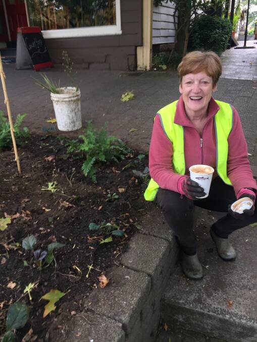Sue de Brett enjoying a coffee break while volunteer gardening in the Mall.