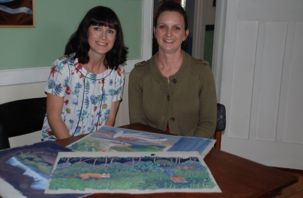 Jodie McLeod and Eloise Short with some of the illustrations for Leonard the Lyrebird.