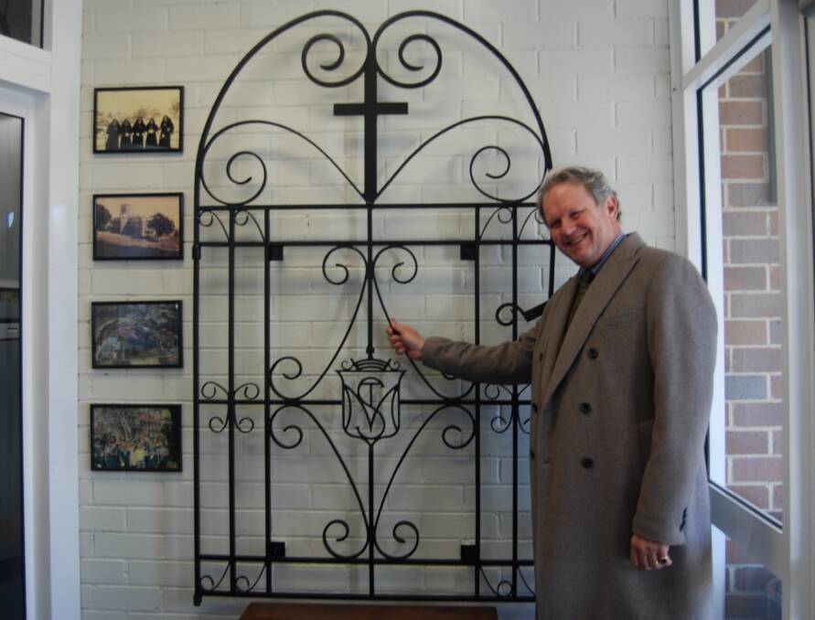 Slice of history: School principal Mark Geerligs with the old Mount St Marys gate, now in the foyer of St Canice's at Katoomba. 
