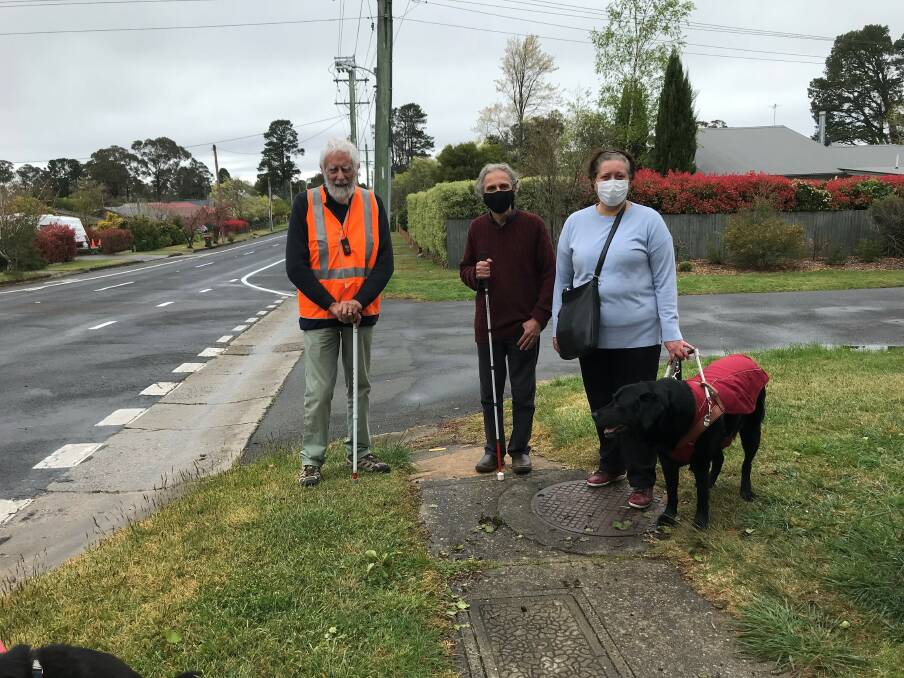 Vision-impaired trio Michael Paddon-Row, Henry Lebovic and Christine Boutsikakis (with guide dog Kit) stand at the junction of Hat Hill Road and Clarence Road, Blackheath, where the footpath runs out.