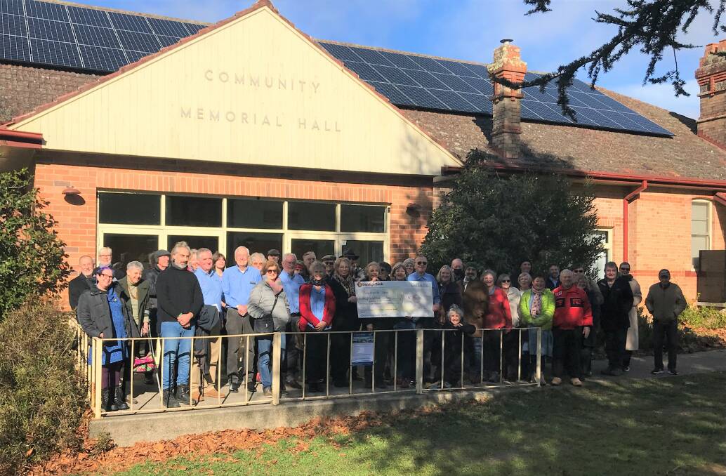Blackheathens and Bendigo Bank board members celebrate the 98 solar panels on the roof of the town's community hall.