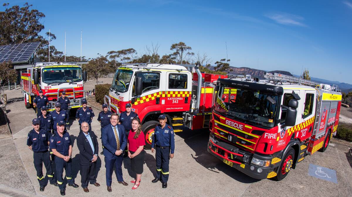 New trucks: Cr Chris Van der Kley, Emergency Services Minister Troy Grant and Blue Mountains MP Trish Doyle with local firies at Echo Point. Photo by Heather Sutton