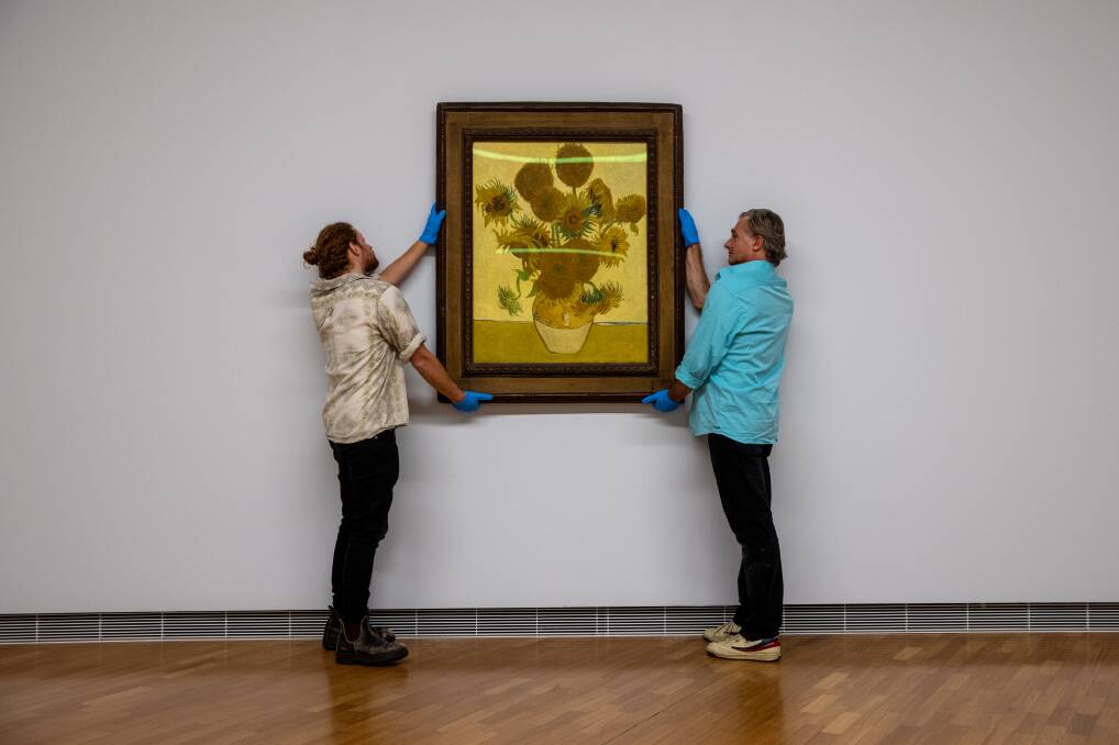 Joel Arthur and Lloyd Hurrell of the National Gallery hang Vincent Van Gogh's famous Sunflowers in the lead-up to the opening of Botticelli to Van Gogh, the gallery's next blockbuster. Picture: Keegan Carroll