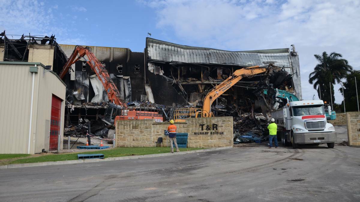 Workers clear away wreckage at Thomas Foods International on Monday. Photo: Peri Strathearn.

