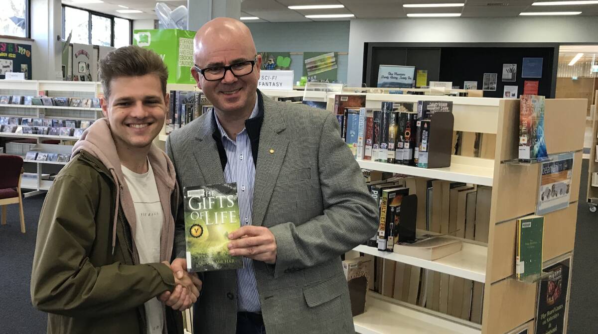 With lots to write: Oliver Smuhar's debut novel The Gifts of Life, is now available at Blue Mountains Library. He's pictured with Blue Mountains mayor Mark Greenhill.