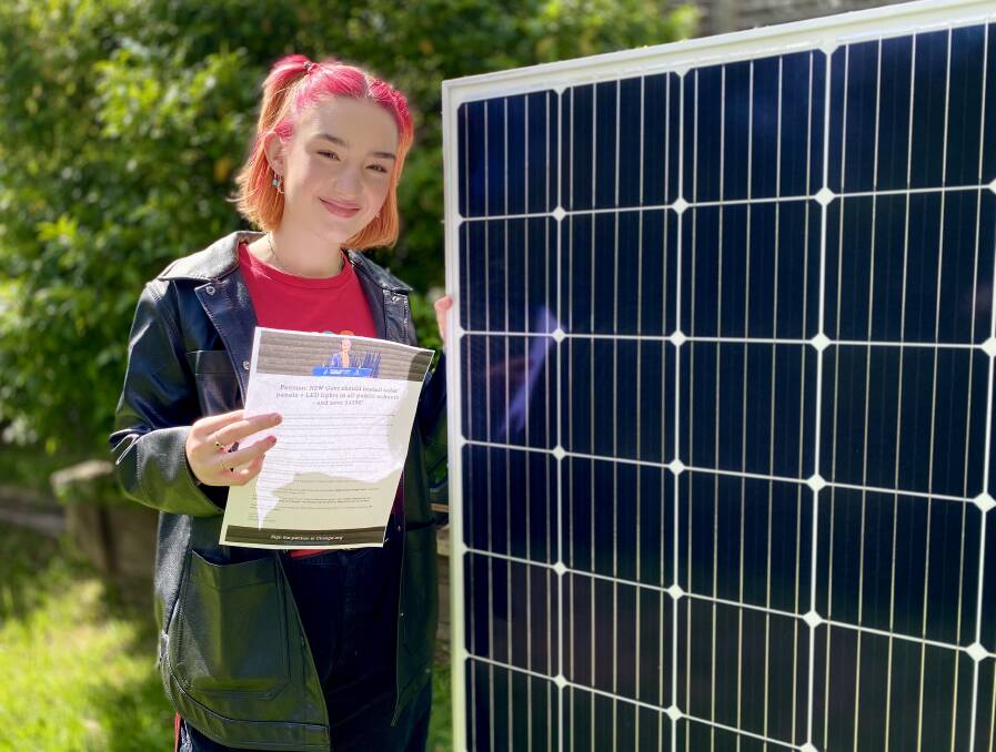 Estelle Dee with her petition, campaigning for solar panels and LED lighting in all NSW public schools within three years.