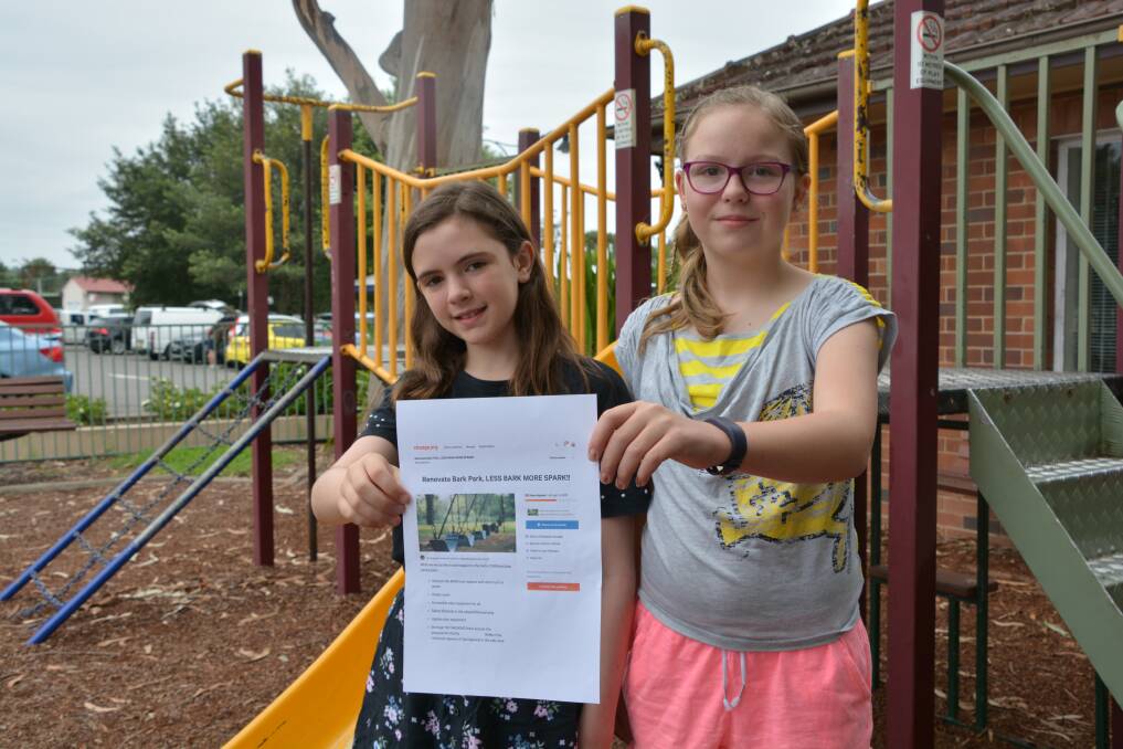 Less bark, more spark: Jasmine Vogel and Olivia Mountain with the petition they started to renovate the park in Springwood.