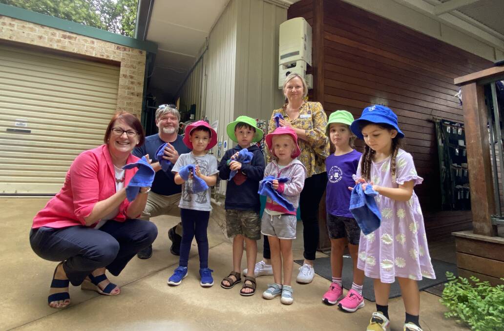 Federal Member for Macquarie Susan Templeman with Blaxland Preschool Kindergarten management board member George Dyke, Director Deirdre Wilde and children using the hand towels washed and dried using solar power. The solar inverter is pictured behind the group.
