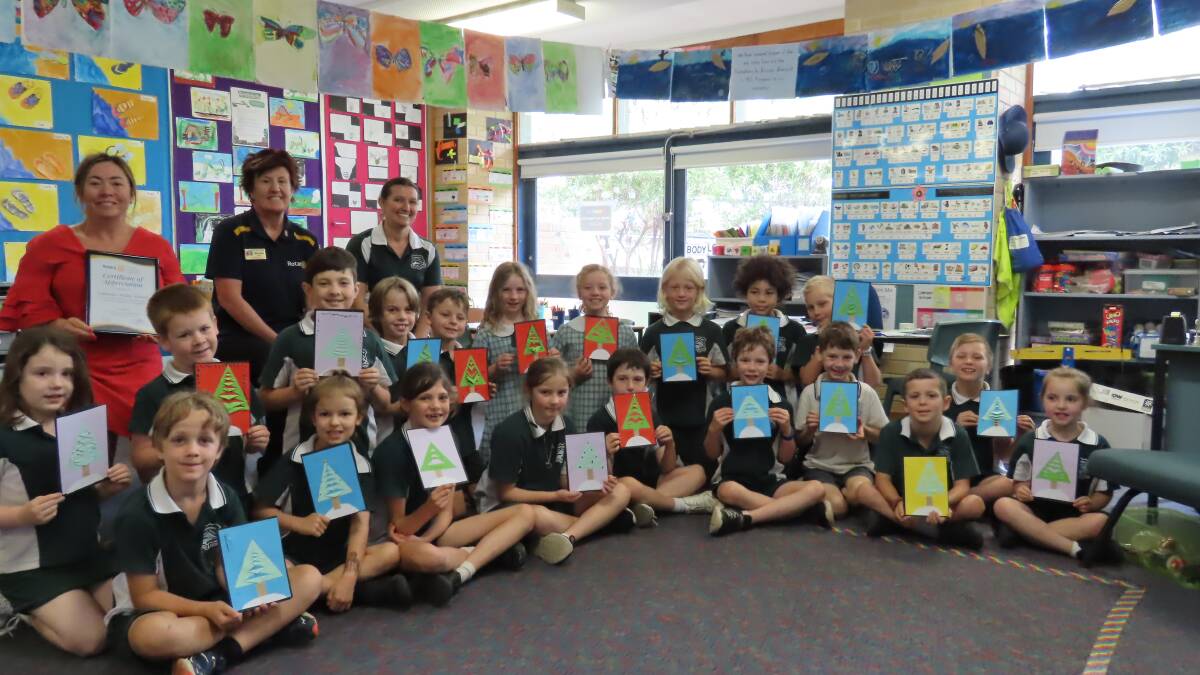 From left, Lapstone Public School principal Sharon Gordon, Rotary President Michele Ellery and teacher Lisa Phelan are with students displaying Christmas cards for 'Young at Heart' senior citizens.