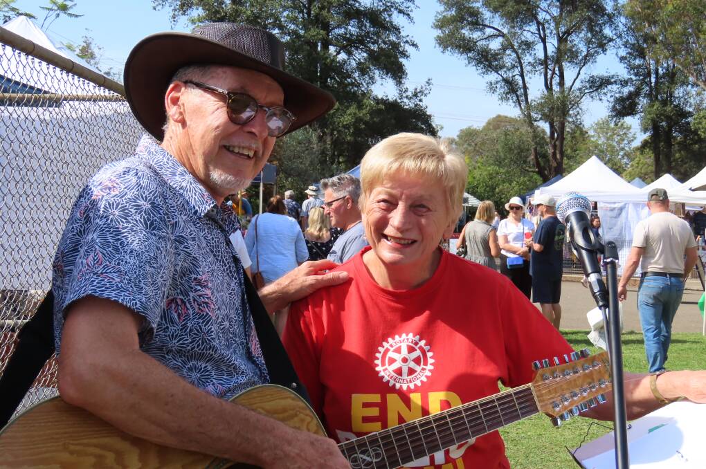 Rotarian and market organising team member Jan Clark welcomes busker Geordie Conyngham to his site and the Rotary market music scene.