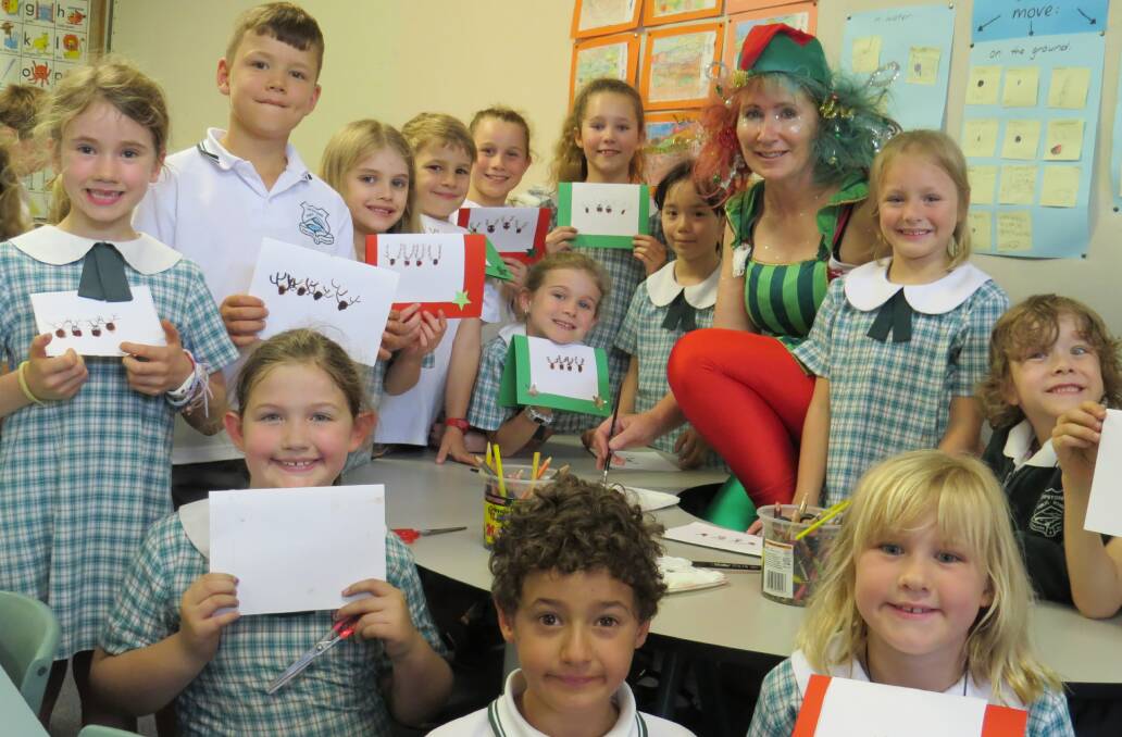Lower Blue Mountains Rotarian ‘Christmas elf’ Kerry Gunn with the hard working group of Lapstone Primary School pupils working on the ‘Young at Heart’ Christmas cards for December 8.
