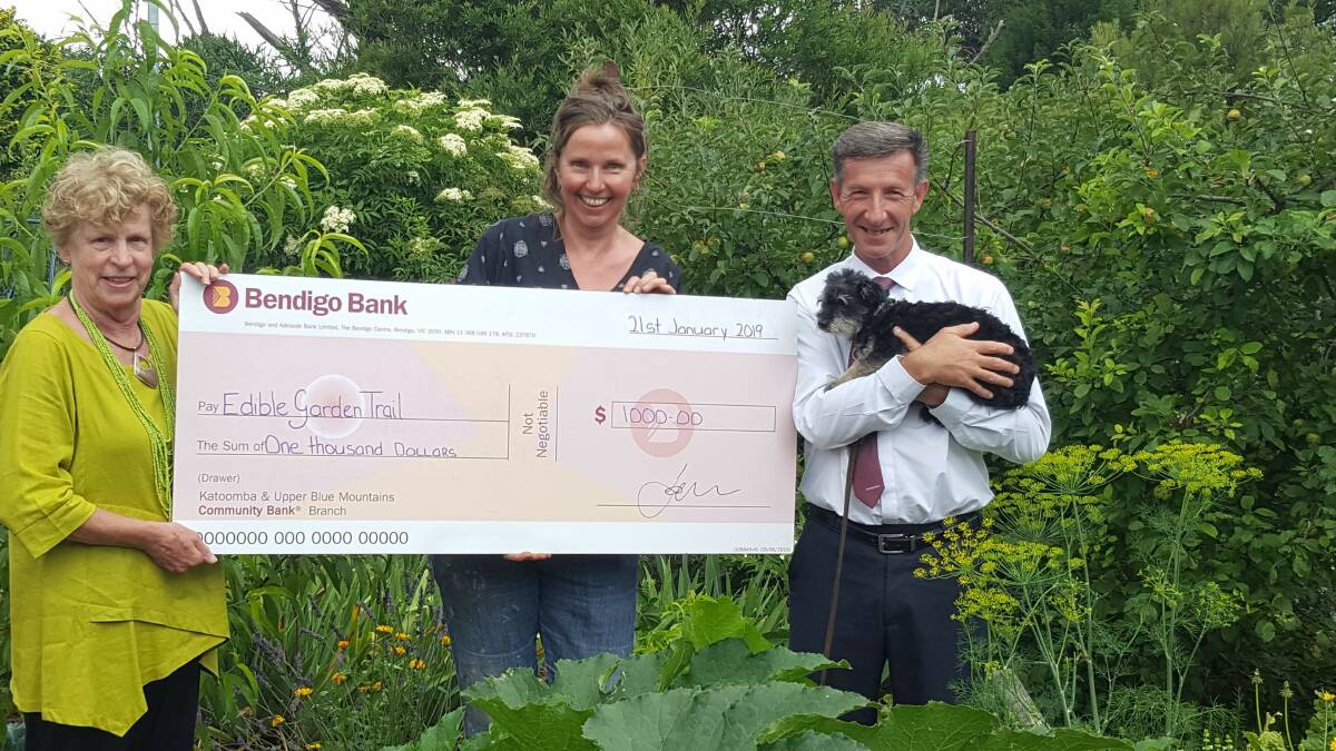 Gardens full of goodness: Edible Garden Trail founder Susanne Rix, Blue Mountains Food Co-op manager Halin Nieuwenhuyse and Bendigo Bank's Vince Tropiano with Pepper the dog. The bank supports the event.

 