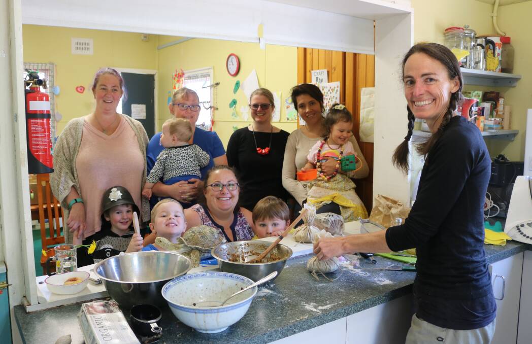 Nourishing Families facilitator, Danielle O'Donoghue, demonstrates nutritious cooking ideas to families at North Katoomba Community Hub. Back row, from left, Jeni, Charmaine (holding Sam), Jackie Spolc, Iman (holding Zahra). Front row, from left, Oscar, Myles, Trudy, Charlie and Danielle O'Donoghue.