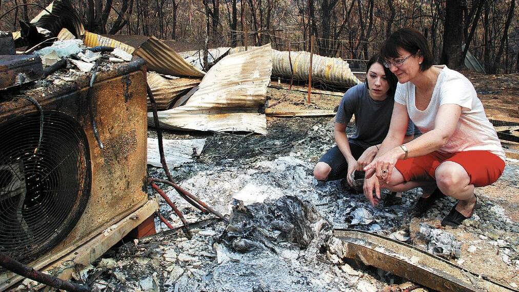 Susan Templeman surveys the remains of her family home in Winmalee with her daughter Phoebe in 2013 after the home was destroyed by bushfire.