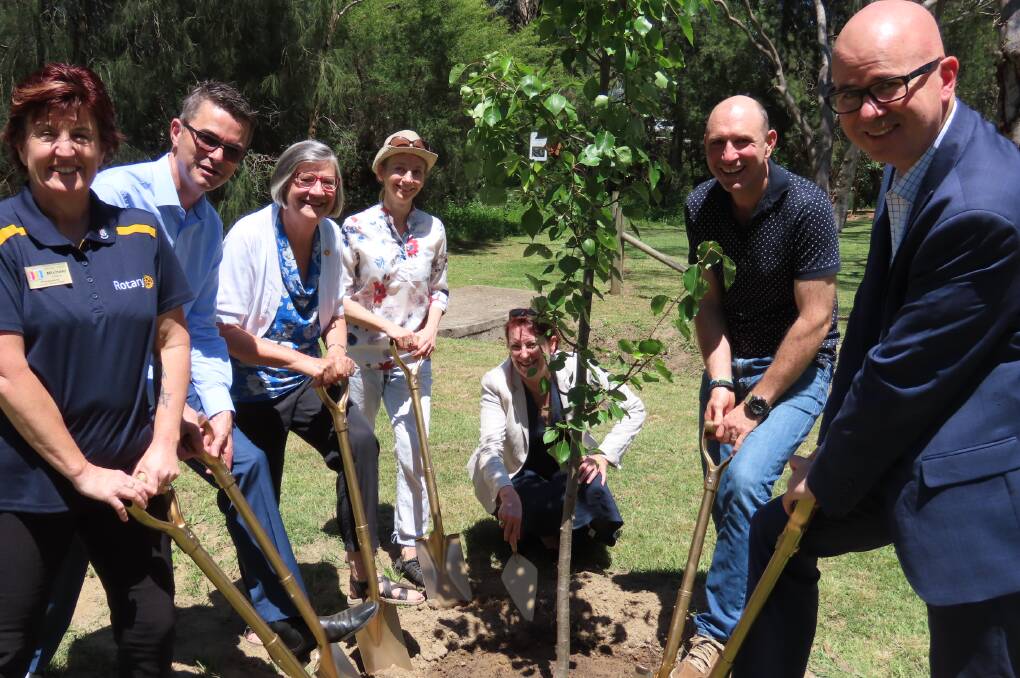Planting commemorative trees in Whitton Park - from left, President Michele Ellery, Hon Shayne Mallard MLC, Carolyn Cook, Nina Cook, Susan Templeman (kneeling), Richard Cook and Mayor Greenhill OAM.