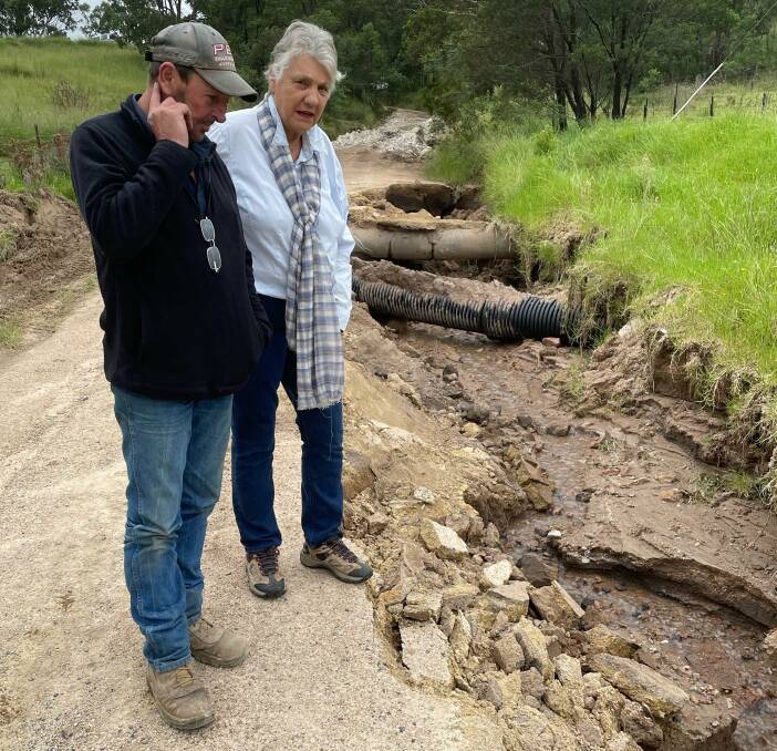 Inspecting the remains of Peach Tree Rd in May this year: Catherine Harris and neighbour Mark Phillis.