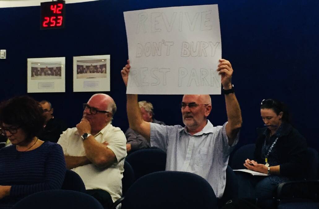 Stephen Foote of Springwood holds up a placard at the council meeting which states: Revive, Don't Bury Rest Park.