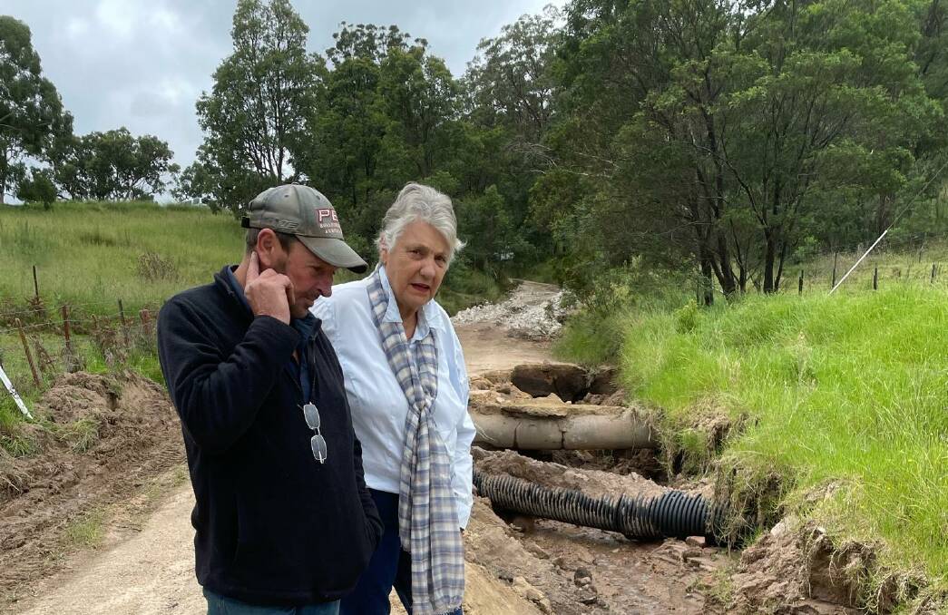 The roads are dire are repeated bad weather events: Catherine Harris and neighbour Mark Phillis inspecting the remains of another Valley road - Peach Tree Rd - in May this year. Picture supplied.