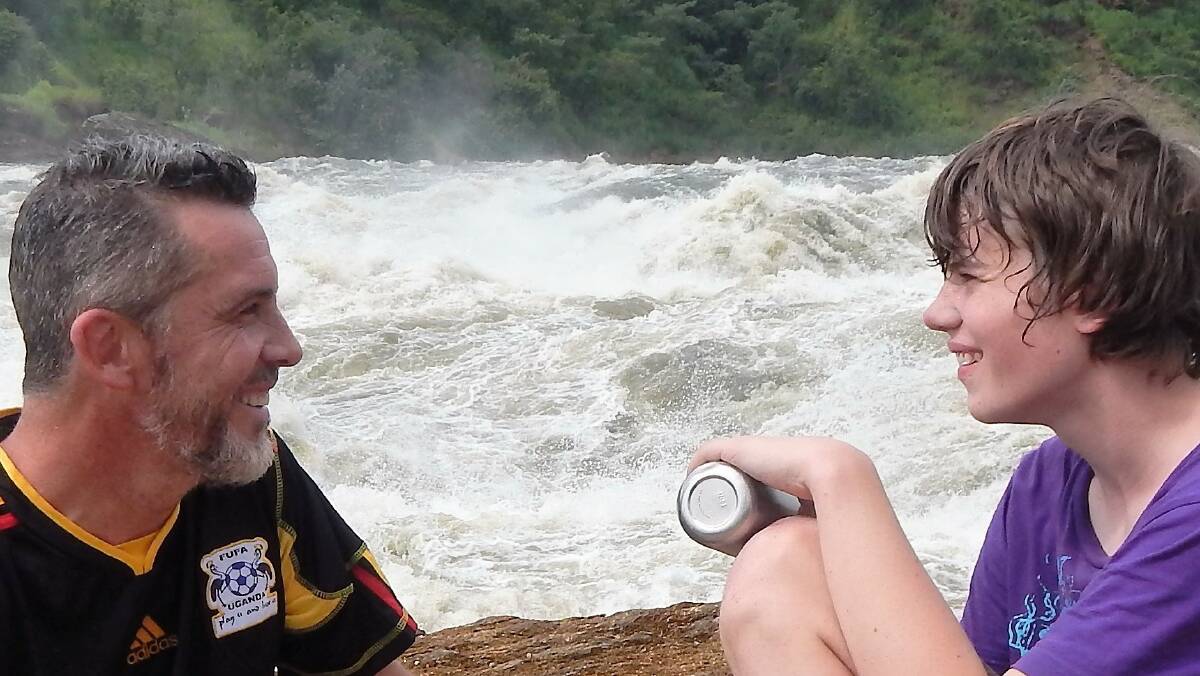 On an adventure: Dr James Best with his son, Sam, sitting next to the Victorian Nile in Uganda. 