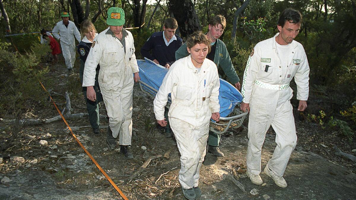Rescue workers remove the body of a female British backpacker after it was discovered in the Belanglo State forest in 1992. Photo: Les Smith
