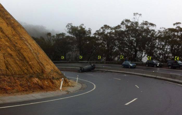 A car on its roof following a crash at Victoria Pass mid-morning on June 6. Photo: Kim Draguns.
