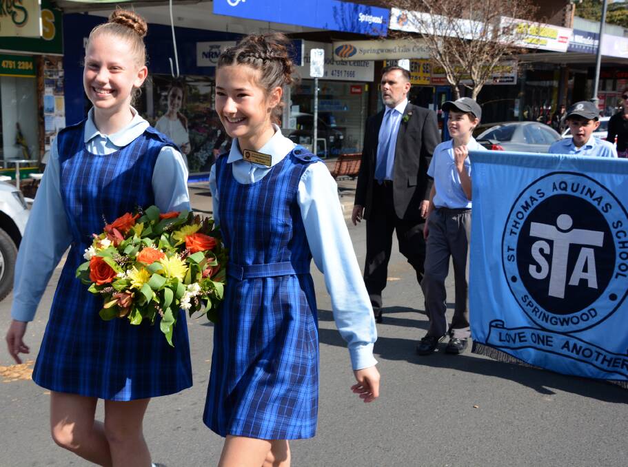 Youthful presence: Isabella Valle and Tia Foley lead the St Thomas Aquinas Primary School contingent in the memorial parade in front of principal Sergio Rosato and students James Glasson and Dylan O'Flanagan.