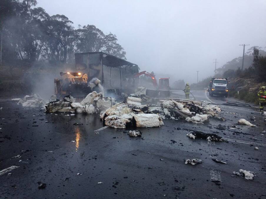 NSW Fire and Rescue crews extinguish the remaining flames in spilt cotton bales at the scene of a truck crash at Mt Boyce on June 5. Photo: NSW Fire and Rescue,  Facebook.